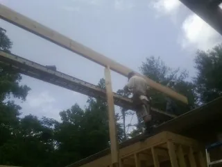 Carpenter setting a ridge beam over a new addition frame — Ice Dam Removal by Roofing Brothers in Juliaetta