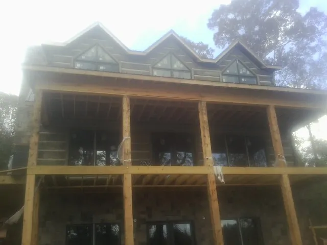 Dormers and porch framing on a large log home under construction — Roof Coating work by our crew in Juliaetta